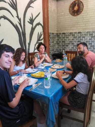 a group of people sitting around a table eating at Ohiya Alpine River Lodge in Ohiya