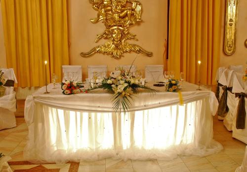 a table with a white table cloth and flowers on it at Hotel Kreta in Galaţi