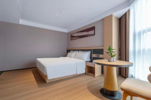 a hotel room with a bed and a table at YIBON INTERNATIONAL HOTEL in Guiyang