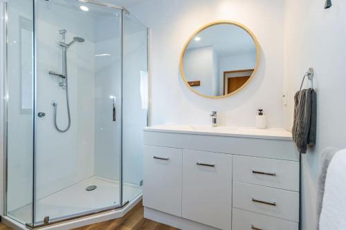 a bathroom with a shower and a sink and a mirror at Little Black Ski Chalet | Central, WiFi, Families! in Methven