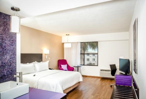 a hotel room with a bed and a tv at Fiesta Inn Saltillo in Saltillo