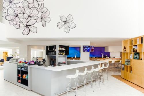 a kitchen with a bar with stools at Fiesta Inn Saltillo in Saltillo
