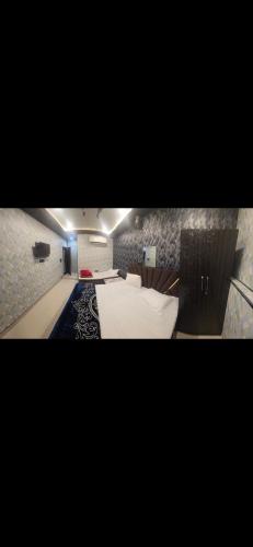 a bedroom with a large bed with white sheets at Aashvi Guest House in Ayodhya