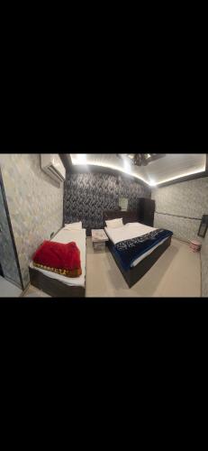 a room with two beds and a table in it at Aashvi Guest House in Ayodhya