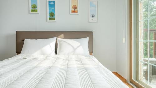 a white bed with white pillows in a bedroom at Taean Atirans Beach Pension in Taean
