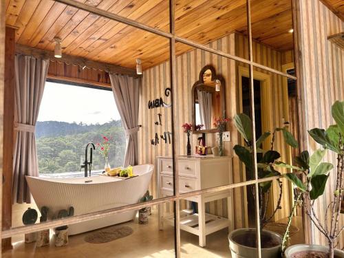 a bathroom with a tub and a sink and a mirror at Cabin In The Air in Ấp Ða Lợi