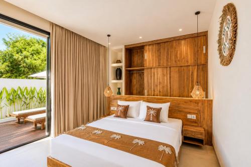 a bedroom with a bed and a balcony at Santo Villa Uluwatu in Bingin Beach