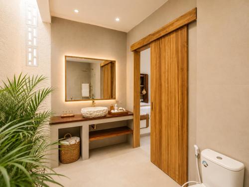 a bathroom with a sink and a mirror at Santo Villa Uluwatu in Bingin Beach