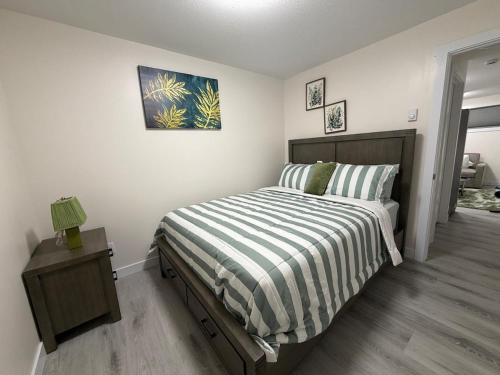 a bedroom with a bed with a striped comforter at Havilah Cozy in Regina