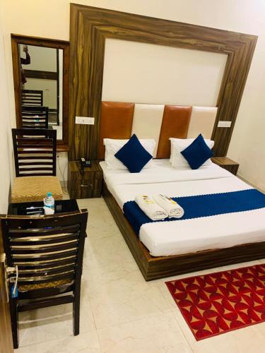 a bedroom with a large bed with blue pillows at Hotel Wooodcrestt Zirakpur in Zirakpur