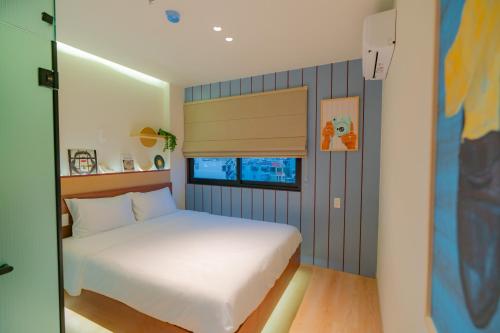a bedroom with a white bed and a window at Benri Hotel Signature in Ho Chi Minh City