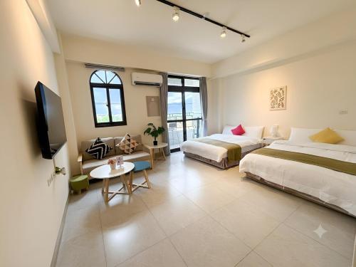 a hotel room with two beds and a tv at 雀居民宿 in Yuli