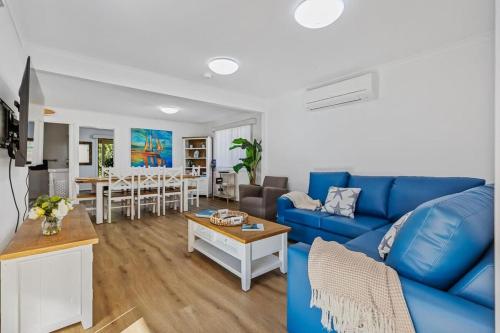 a living room with a blue couch and a table at Winnies on Sunpatch in Tomakin