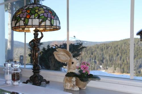 a stuffed rabbit sitting on a window sill next to a lamp at Hotel Diana in Feldberg