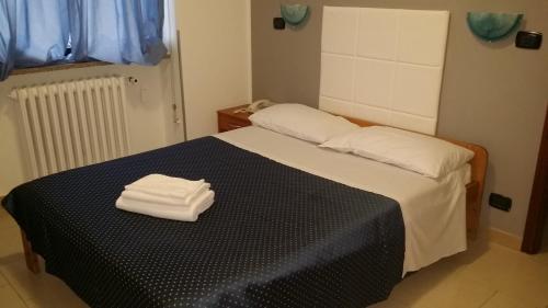 a bedroom with a bed with two towels on it at Flying Hotel in San Maurizio Canavese