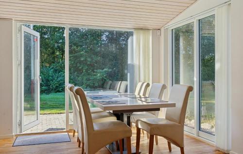a dining room with a table and white chairs at Awesome Home In Bording With Sauna in Korning