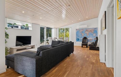 a living room with a couch and a tv at Awesome Home In Bording With Sauna in Korning