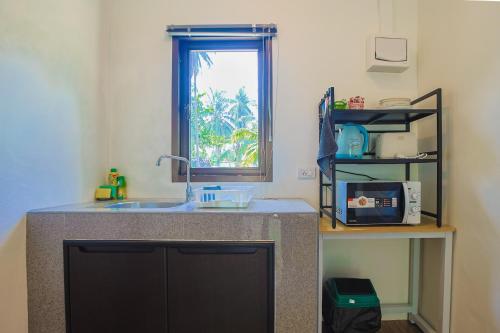 a kitchen with a sink and a window at First light beach hin kong in Hinkong