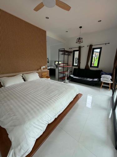 a bedroom with a large bed and a living room at Khao Raa Terrace 6 in Ko Phangan