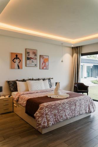 a bedroom with a large bed and a window at Hôtel Touraco in Assinie