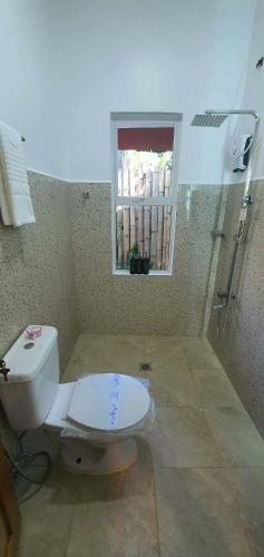 a bathroom with a toilet and a window at lala-Oh Resort in Lalao