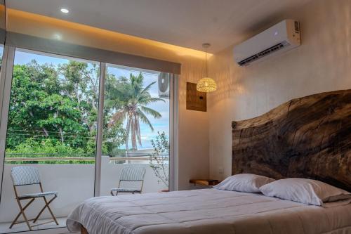 a bedroom with a large bed and a large window at Japandi Las Islas in Puntarenas