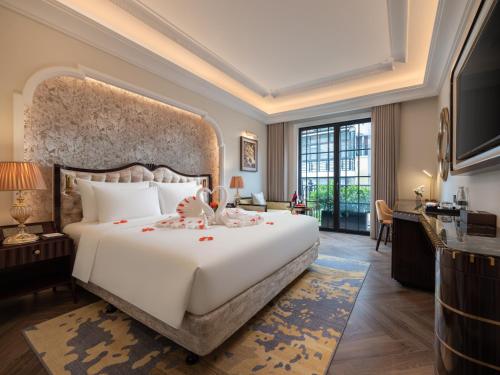 a bedroom with a large white bed and a large window at Classyc Hotel Hang Buom in Hanoi