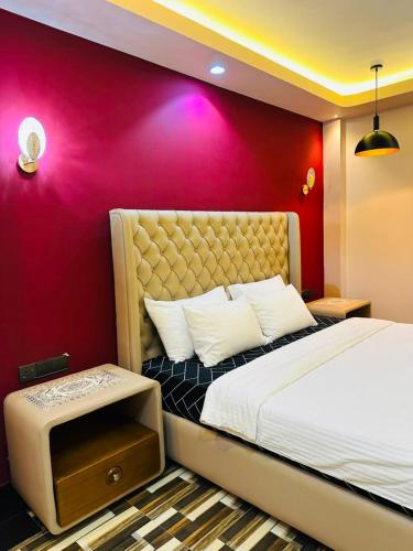 a bedroom with a large bed with a red wall at Feather Villa in Talpe