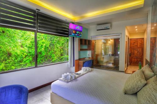 a bedroom with a bed and a large window at Las Luciernagas Hotel in Flores