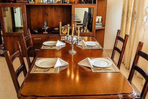 a wooden table with plates and napkins on it at The Negombo Manor Villa in Negombo