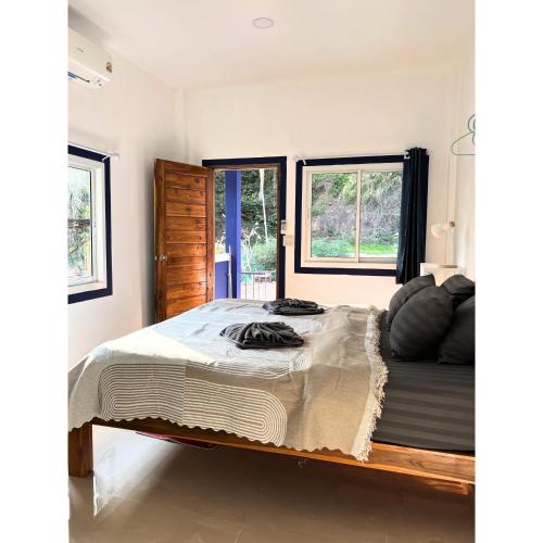 a bedroom with a large bed and two windows at Blue House Klong Hin in Ko Kood