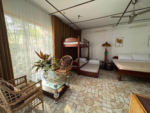 a bedroom with a bed and a couch and a table at Deep Forest Garden Hotel in Puerto Princesa City