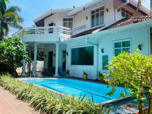a house with a swimming pool in front of it at The Negombo Manor Villa in Negombo