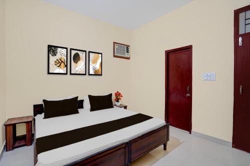 a bedroom with a large bed and a red door at Hotel O Chandigarh Outer Ring Road Formerly Ganesha in Chandīgarh