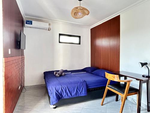 a bedroom with a bed and a desk and a table at Devata 68 Private Room VIP in Uluwatu