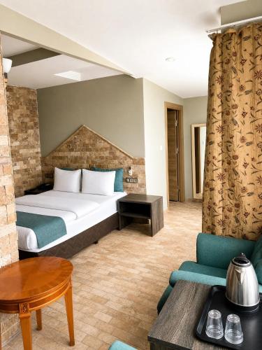 a hotel room with a bed and a table at Grand Park Hotel Corlu City Center Bed and Breakfast in Çorlu