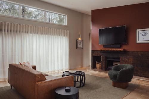 a living room with a couch and a television at Clayfields Hunter Valley in Pokolbin