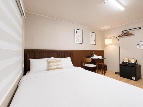 a bedroom with a large bed and a desk at 페블스테이 남포점 in Busan