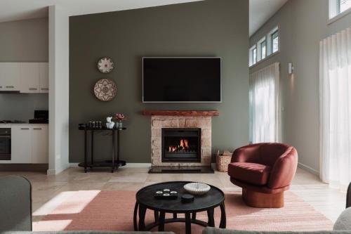 a living room with a fireplace and a flat screen tv at Clayfields Hunter Valley in Pokolbin