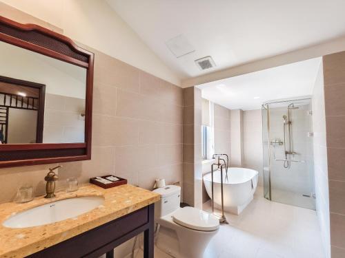 a bathroom with a sink and a tub and a toilet at Virgo Villa Quê Hội An in Hoi An
