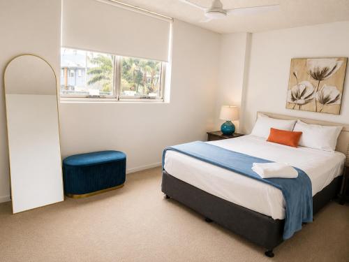 a bedroom with a large bed and a window at Tradewinds Apartments in Coffs Harbour