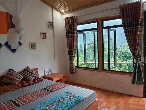 a bedroom with a bed and a large window at Homestay Hoàng Vũ in Ha Giang