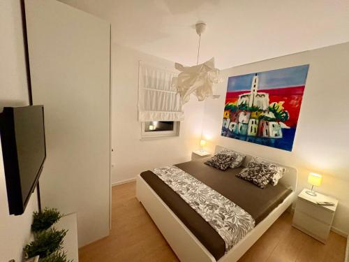 a bedroom with a bed and a painting on the wall at Anapartments2 in Primošten