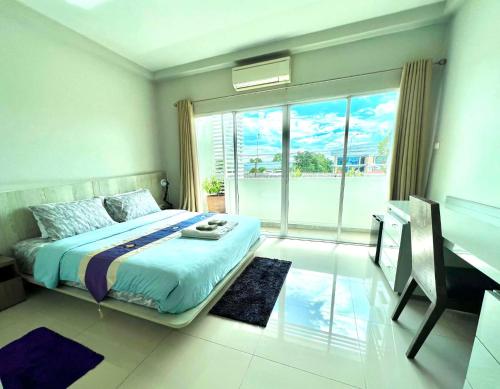 a bedroom with a bed and a desk and a window at Brianna Balcony Apartment in Ban Ton Chok