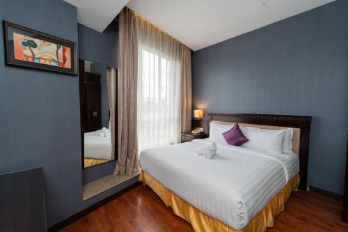a bedroom with a large bed and a mirror at Kingston Hotel 18 - Kuala Lumpur Sri Damansara in Kuala Lumpur