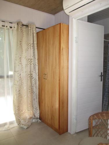 a room with a curtain and a wooden cabinet at Hotel Restaurant Paraiso TINY in Villarrica