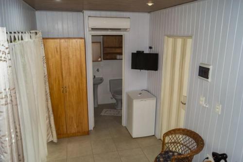 a room with a bathroom with a toilet and a television at Hotel Restaurant Paraiso TINY in Villarrica