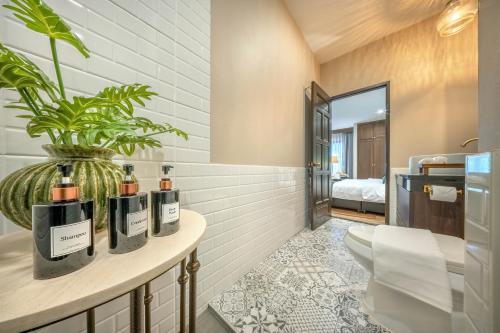 a bathroom with a table with bottles of wine at Apirom Hometel in Sathani Lak Si