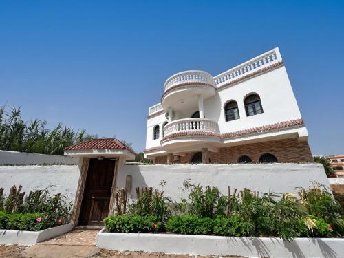 a large white house with a balcony on top at Villa TAHA piscine jacuzzi clim in Martil