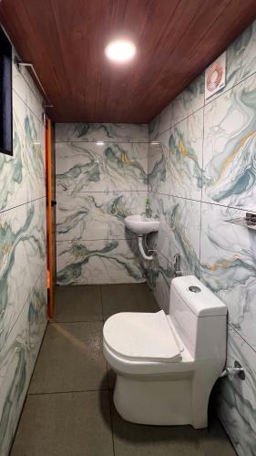 a bathroom with a toilet and a sink at Tribez Valley Resort in Anaviratty